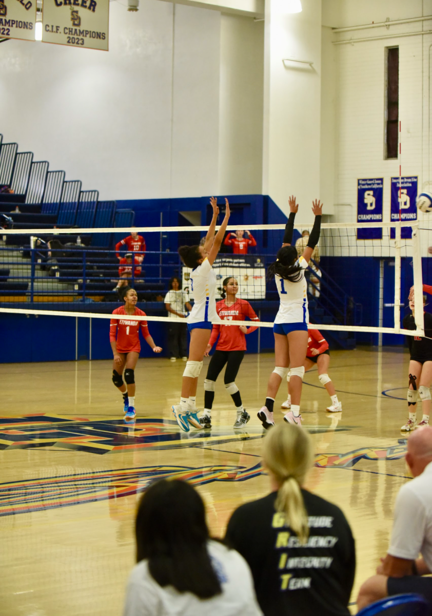 Sophmore Sophie Atalla jumping up to block a spike sent by Etiwanda